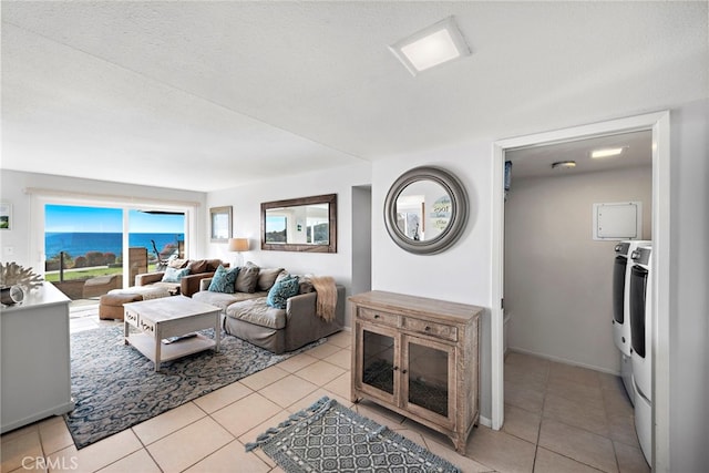 living area with light tile patterned floors, separate washer and dryer, and a textured ceiling