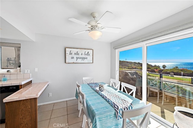 dining room featuring light tile patterned floors, ceiling fan, and baseboards