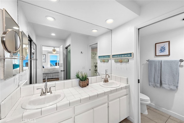 bathroom with tile patterned floors, a sink, toilet, and double vanity