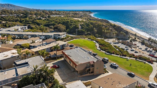 birds eye view of property with a water view and a beach view