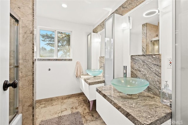 bathroom featuring enclosed tub / shower combo and vanity