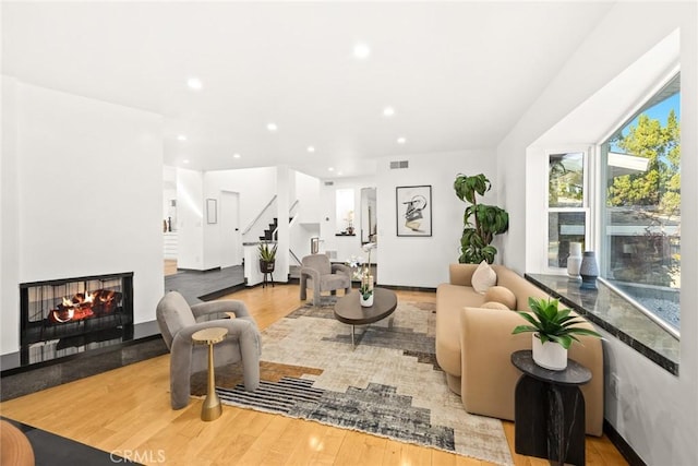 living room with hardwood / wood-style flooring and a multi sided fireplace