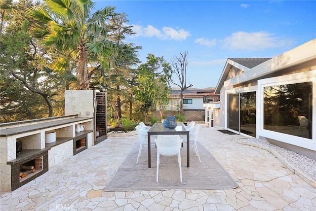 view of patio with exterior kitchen and a fireplace