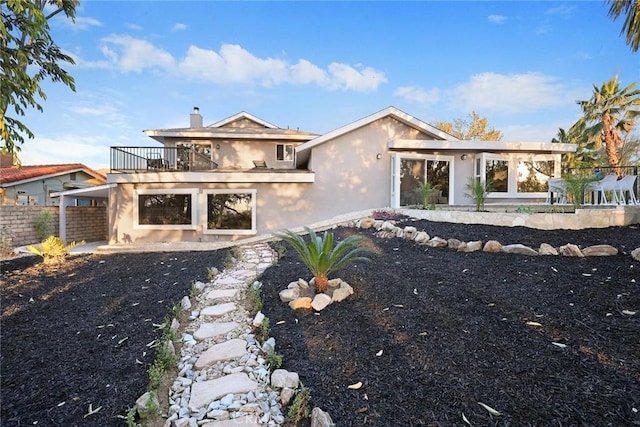 rear view of property featuring a balcony