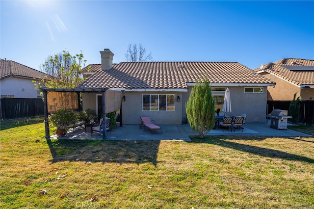 rear view of house with a patio and a yard