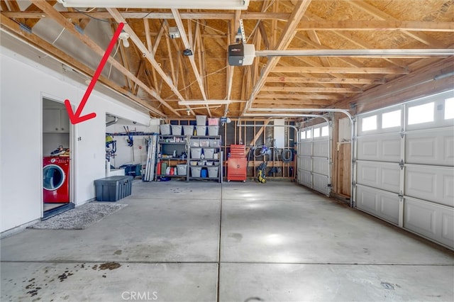 garage featuring a garage door opener and washer / dryer