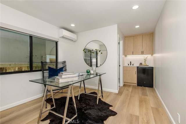 home office featuring an AC wall unit, sink, and light hardwood / wood-style flooring