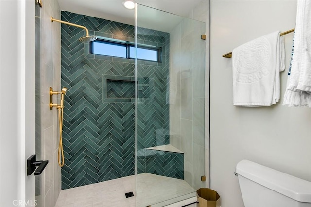 bathroom featuring toilet and tiled shower