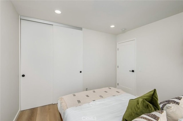 bedroom with a closet and light hardwood / wood-style flooring