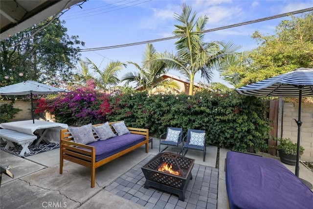 view of patio / terrace with an outdoor living space with a fire pit