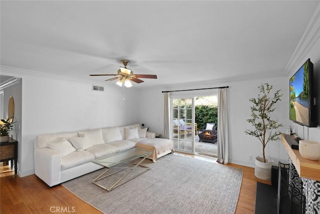 living room featuring hardwood / wood-style flooring, ceiling fan, and ornamental molding