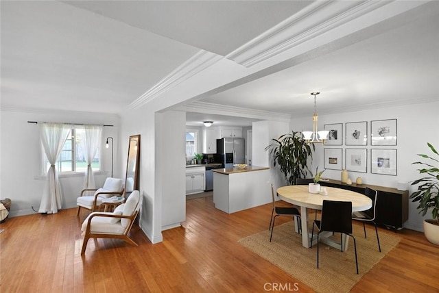 dining room with light hardwood / wood-style floors and ornamental molding