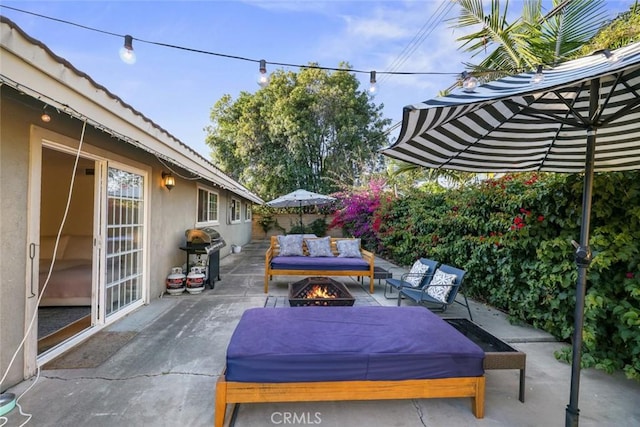 view of patio with area for grilling and an outdoor living space with a fire pit