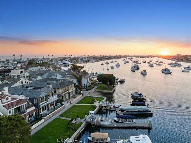 aerial view at dusk featuring a water view