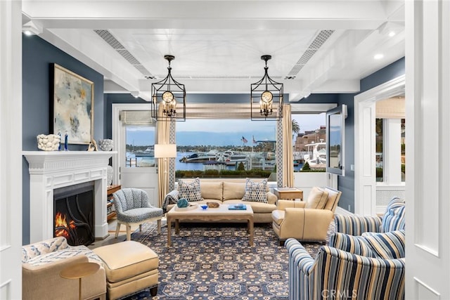 living room with beam ceiling, a water view, and a chandelier