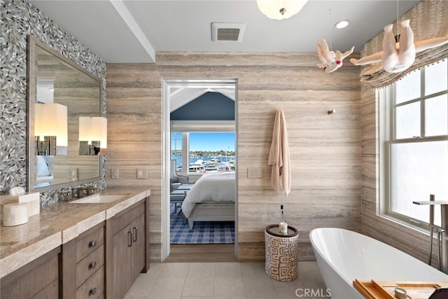 bathroom with tile patterned flooring, vanity, and a tub