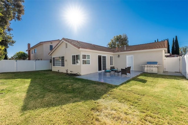 back of property with a lawn and a patio area