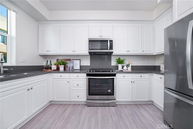 kitchen with white cabinets, light wood-type flooring, sink, and appliances with stainless steel finishes