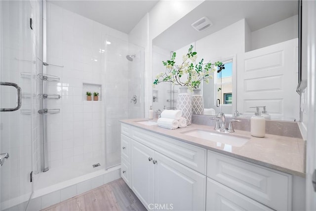 bathroom featuring vanity, hardwood / wood-style flooring, and a shower with shower door