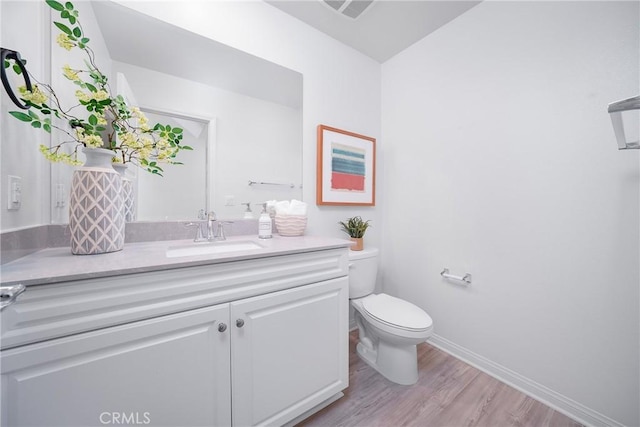 bathroom with hardwood / wood-style floors, vanity, and toilet