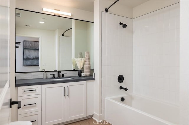 bathroom featuring tiled shower / bath combo and vanity