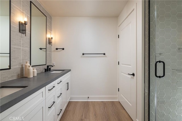 bathroom featuring hardwood / wood-style floors, vanity, and a shower with door