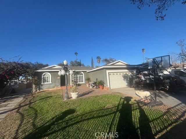 single story home with a garage and a front lawn