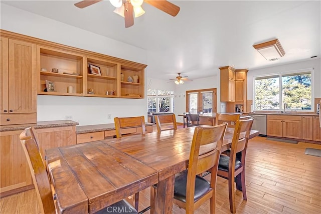 dining room with ceiling fan, sink, and light hardwood / wood-style flooring