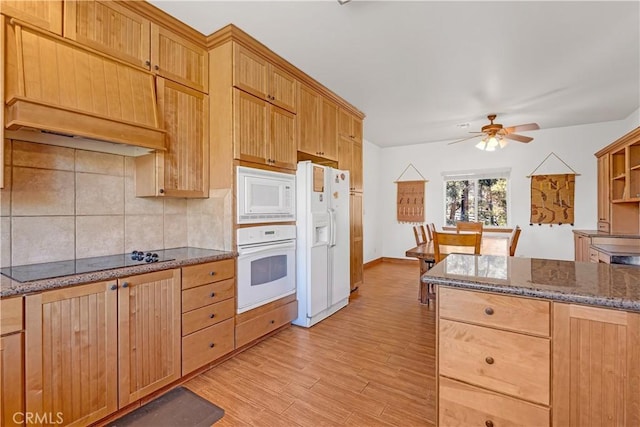 kitchen featuring ceiling fan, tasteful backsplash, white appliances, light wood-type flooring, and dark stone counters