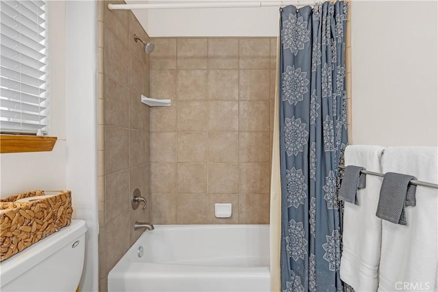 bathroom featuring toilet, a healthy amount of sunlight, and shower / bath combination with curtain