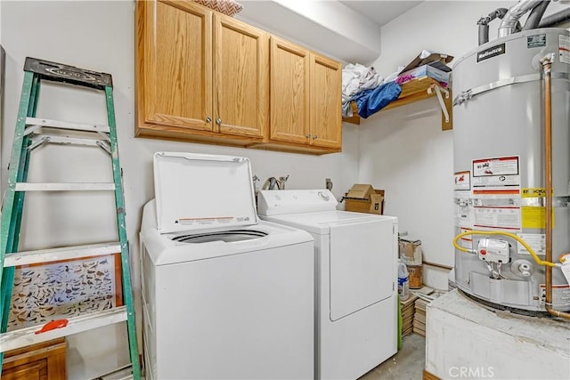 washroom with cabinets, washer and dryer, and strapped water heater