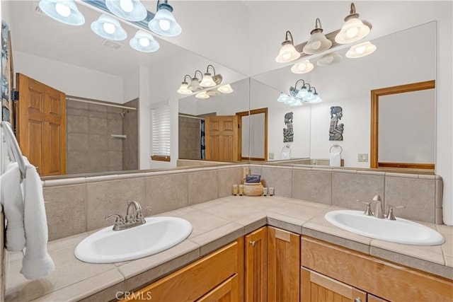 bathroom featuring decorative backsplash, tiled shower, and vanity