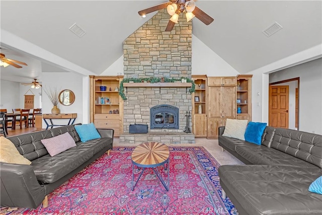 living room with ceiling fan, a stone fireplace, and high vaulted ceiling