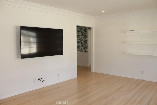 empty room featuring crown molding and light wood-type flooring