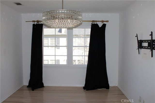 dining area featuring wood-type flooring and an inviting chandelier