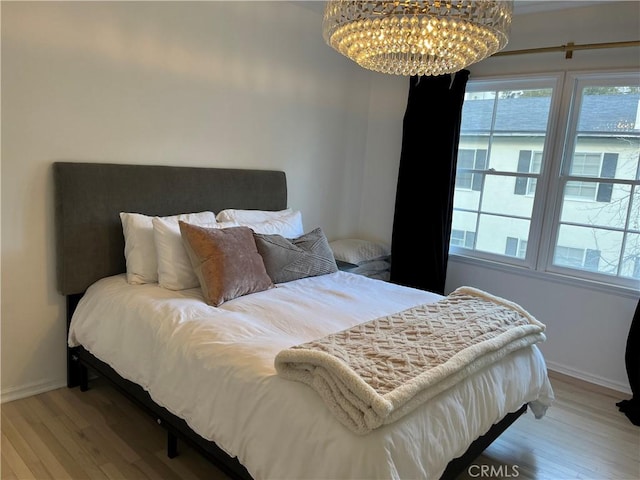 bedroom with a chandelier and wood-type flooring