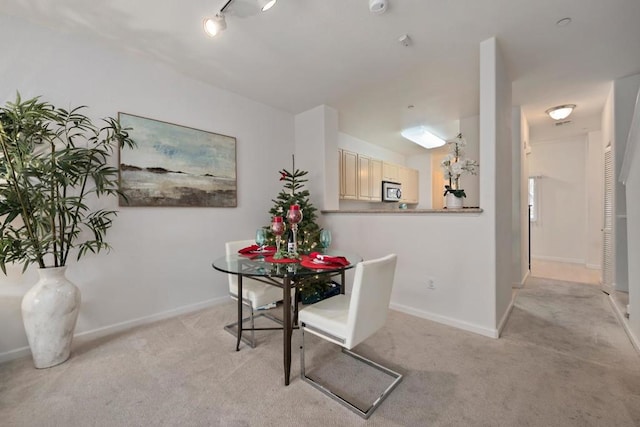 carpeted dining room with rail lighting