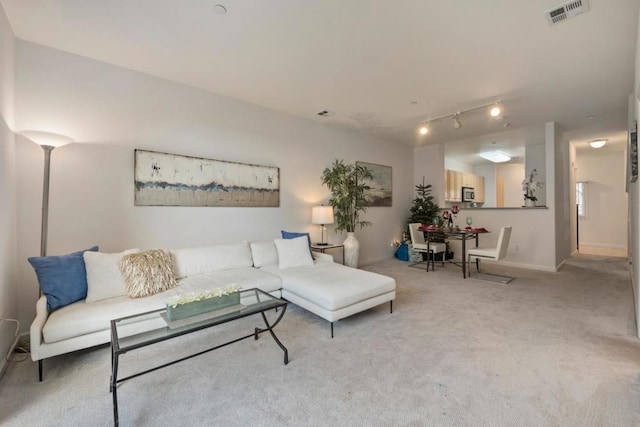 living room with track lighting and light colored carpet