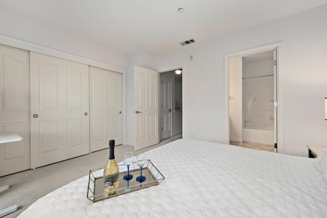 carpeted bedroom featuring a closet and ensuite bath