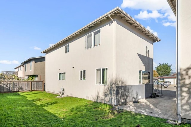 back of house with a patio and a yard