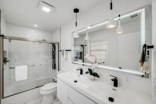 full bathroom featuring vanity, enclosed tub / shower combo, and toilet