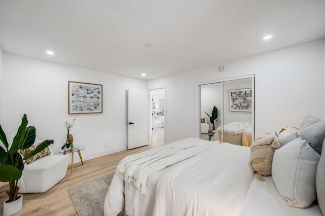 bedroom with light hardwood / wood-style flooring and a closet