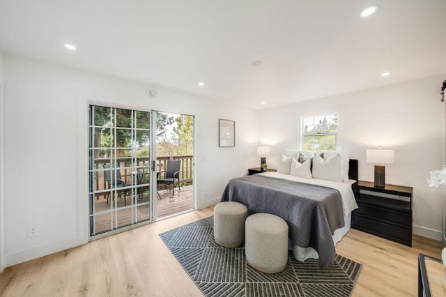 bedroom featuring access to outside, multiple windows, and light wood-type flooring