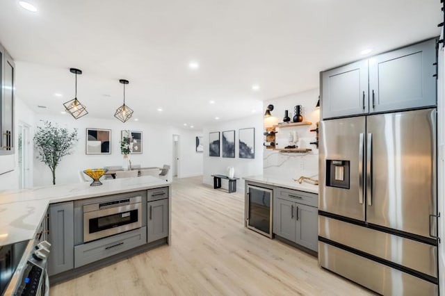 kitchen featuring light stone countertops, stainless steel fridge with ice dispenser, beverage cooler, and gray cabinetry