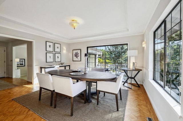 dining room with parquet floors and a tray ceiling