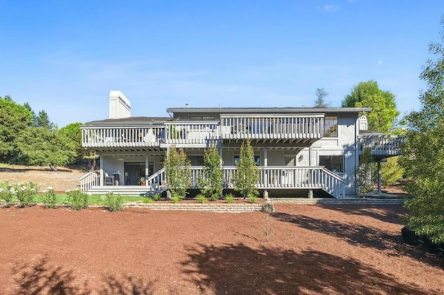 rear view of house featuring a wooden deck