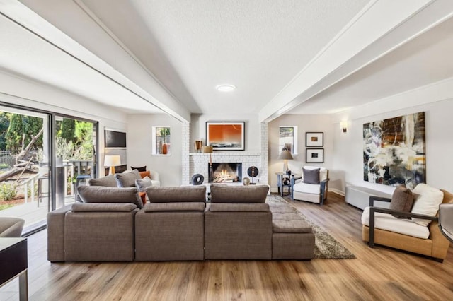 living room featuring wood-type flooring and a brick fireplace