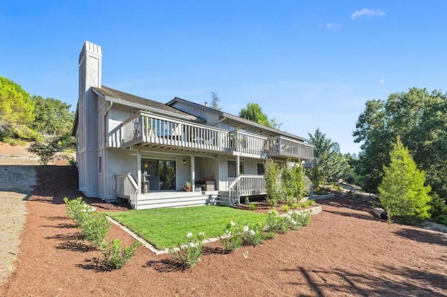 back of property with a wooden deck and a yard