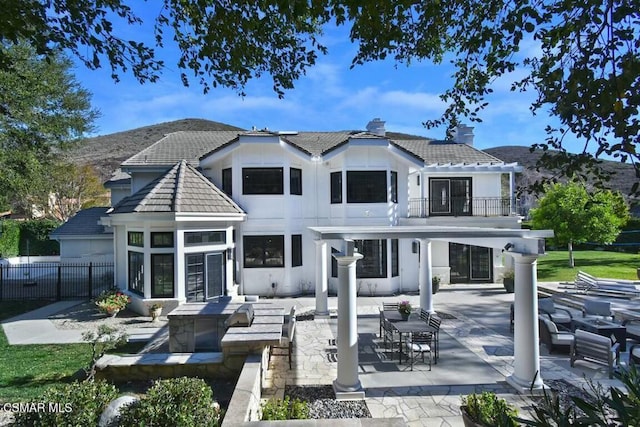 back of house featuring a balcony and a patio area