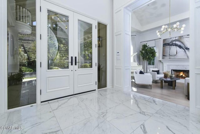 entryway featuring french doors, an inviting chandelier, and a tray ceiling